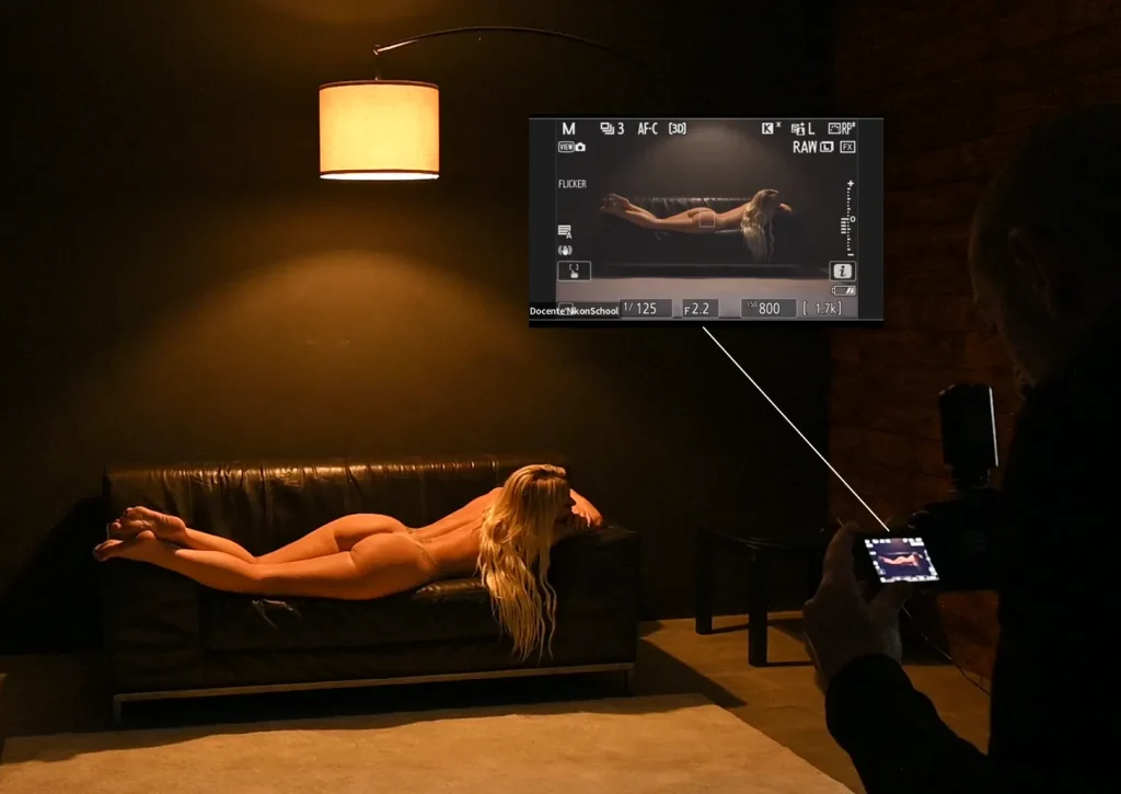 fotografia di nudo con modella bionda su divano in diretta da un reale set fotografico con backstage del monitor della fotocamera di Francesco Francia durante un corso di fotografia di nudo