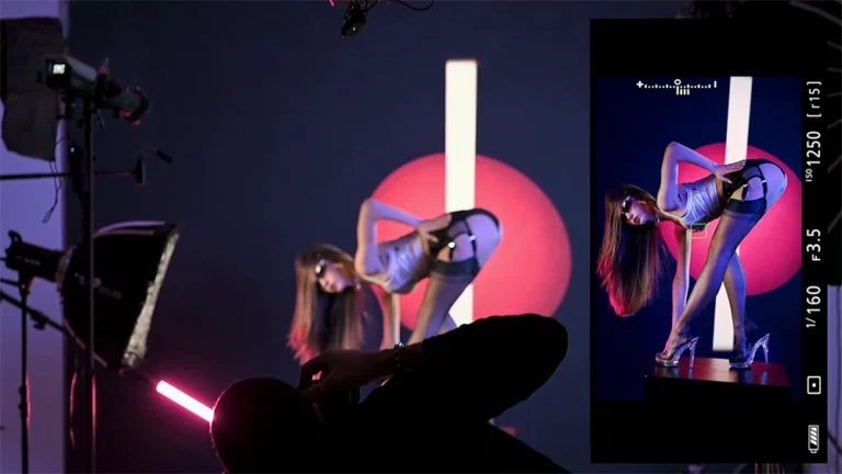 Una modella china su se stessa in abbigliamento fashion spaziale argento futurista con dietro uno sfondo con un cerchio rosso fatto di luce backstage della MASTERCLASS di illuminotecnica fotografica con Francesco Francia fotografo di moda e docente di fotografia